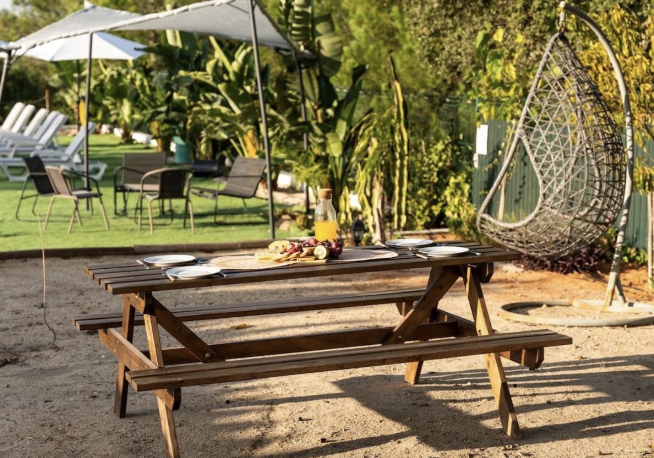Jardim com mesa de piquenique e zona lounge
